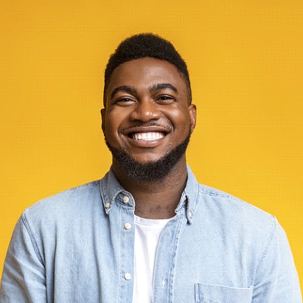 smiling man in front of a yellow background