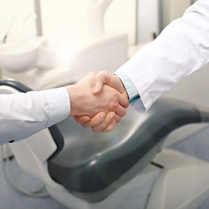 Shaking hands with dentist after getting dentures in Virginia Beach, VA