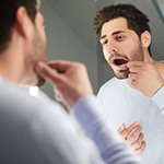 Man looking at lost filling in the mirror